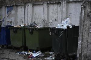 vuilniscontainers en zakken met afval op straat foto