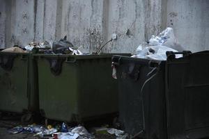 vuilniscontainers en zakken met afval op straat foto