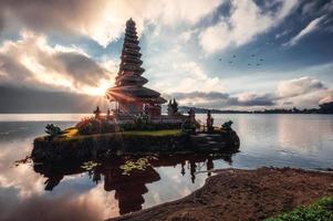 zonsopgang schijnt op de oude tempel van pura ulun danu bratan op bratan meer in bali foto