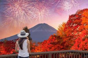 jonge Aziatische vrouw die Fuji-san bezoekt met vuurwerkviering in het herfstseizoen foto