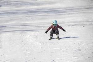 klein meisje leert skiën op een skipiste foto