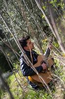 jongen speelt gitaar midden in de natuur foto