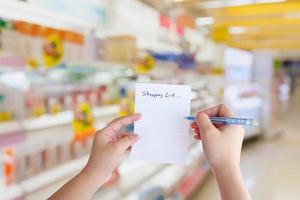 hand houden boodschappenlijstje papier met supermarkt foto