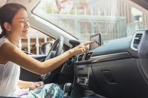 vrouw rijdende auto met hand aanraken van navigatie op beeldscherm. foto