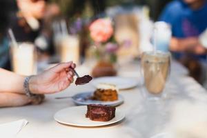 hand met lepel heerlijke chocoladetaart eten in café. foto