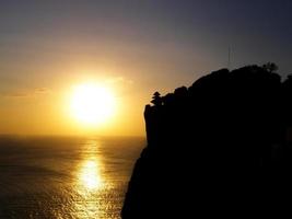 zonsondergang aan de oceaankust, het strand van uluwatu, bali, indonesië foto