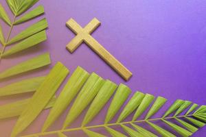 kruis en palmbladeren op paarse achtergrond. uitgeleend seizoen concept. foto