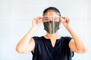 Aziatische vrouwen moeten maskers en gelaatsschermen gebruiken om te beschermen tegen vervuiling door stof en om infecties te voorkomen door afscheidingen die zich in de lucht verspreiden foto