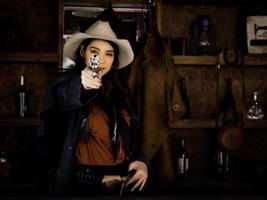 een westerse cowgirl bereidt zich voor om een geweer te gebruiken om zichzelf te verdedigen in een land waar mensen zichzelf moeten beschermen foto