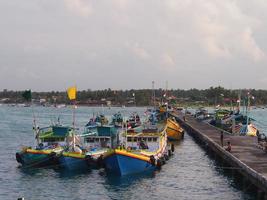 traditionele haven in de ochtend met verschillende vissersboten langszij en mensenactiviteiten op het eiland Masalembu, Indonesië. januari 2020, masalembu - Indonesië foto