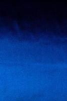 luxe diepblauwe stof background.smooth golvende vouw patroon.elegant curve.silk fluwelen materiële texture.using voor achtergrond of wallpaper.dark toon kleur. foto