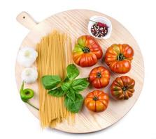 tomaten, knoflookbollen, basilicumblaadjes, spaghetti en pepermix. foto