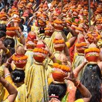 vrouwen met kalash op hoofd tijdens jagannath tempel mangal kalash yatra, indische hindoe toegewijden dragen aarden potten met heilig water met een kokosnoot erop foto
