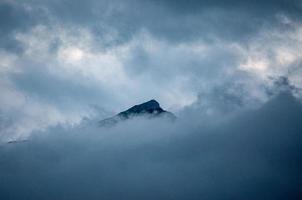 betoverend uitzicht op de berg bedekt met wolken op een mistige dag foto