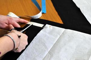 een naai-professionele kleermaker aan het werk om stof te maken foto