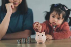 familie geld besparen. aziatische vrouw en dochter zijn van plan om de toekomst serieus, financiën en sparen, familie en financieel concept door te brengen. foto