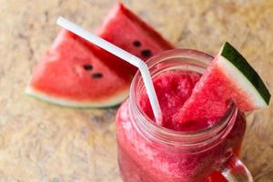 verse watermeloen smoothie in glazen pot op de houten achtergrond foto