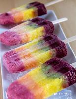 regenboog ijslollys met vers fruit foto