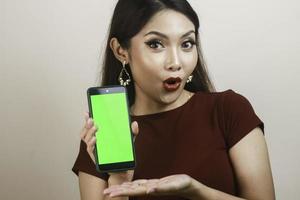 Aziatisch mooi meisje is geschokt door de smartphone met een roodhemd foto
