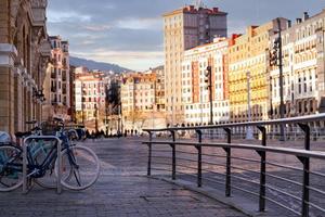 fiets bij fietsstation voor reizen of vervoer in de stad europa. duurzaam reizen. systeem voor het delen van fietsen. fiets geparkeerd bij station op vervagen mensen en oud gebouw in spanje. milieuvriendelijk vervoer. foto