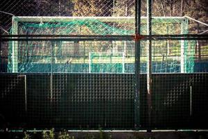 een klein stadion omgeven door een groen metalen hek. foto