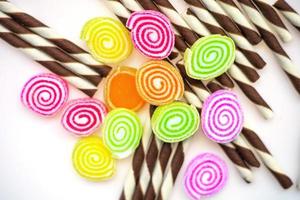 kleurrijke snoepjes en suikerspin op een witte achtergrond foto