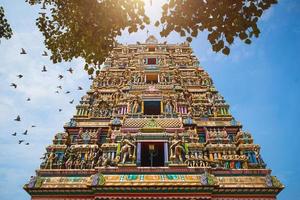 traditionele hindoe tempel kidangamparambu sree bhuvaneswari in india in allapuzha allepi kerala. hoog gebouw met kleurrijke figuren uit de Indiase mythologie en goden, een zwerm levende vogels. toerisme, reizen foto