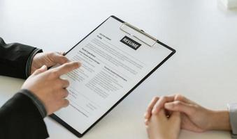 close-up zakenman handen met pen met document tijdens vergadering. man die een beslissing neemt over een zakelijke deal. goede zakenpartners onderhandeling bij sollicitatiegesprek op kantoor. foto