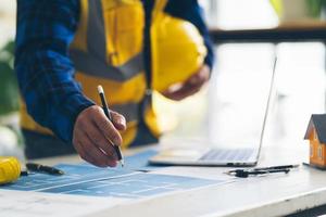 architect man aan het werk met blauwdrukken, ingenieur inspectie op de werkplek voor architectonisch plan, schetsen van een bouwproject, architect en ingenieur concept. foto