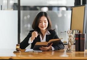 vrouwelijke advocaten openen en lezen met een wetboek op haar werkplek. foto