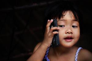 gelukkig babymeisje praten op mobiele telefoon foto