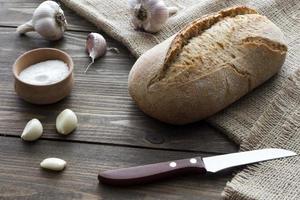 knoflook, zout, brood en een mes foto