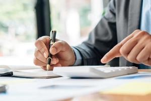 strategie analyse concept, zakenman werken financieel manager onderzoeken proces boekhouding berekenen analyseren markt grafiek data voorraad informatie review op tafel in kantoor. foto