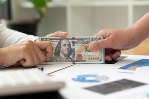 zakenman die geld geeft of betaalt, Amerikaanse dollarbiljetten foto