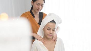 jonge Aziatische mooie vrouw ontspannen en genieten van massage, spa en schoonheidsbehandeling concept foto