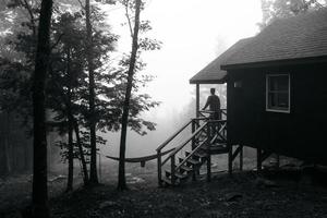 zwart-wit van een silhouet van een persoon bij een huis foto