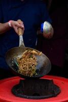 een chef-kok bereidt Chinees eten op een straatvoedselfestival. foto