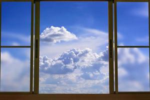 kijk naar de blauwe bewolkte lucht in het raam