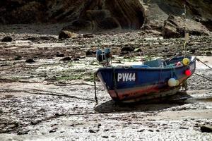 bude, cornwall, uk, 2013. vissersboot strandde op het zand foto