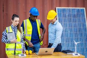 twee mannelijke energie-ingenieurs met zijn vrouwelijke collega-team bespreken nieuw project dat op het punt staat te investeren in het installeren van zonnecellen buiten het gebouw of de industriële fabriek foto