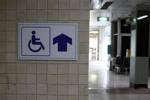 teken rolstoel manier is op lichtbruine muur in gebouw. foto