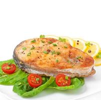 Visschotel - gebakken visfilet met groenten op witte achtergrond foto
