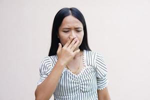 Aziatische vrouwen bedekken hun neus met hun handen omdat ze stinken. foto
