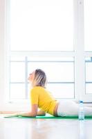 vrij jonge vrouw die yogaoefening thuis doet