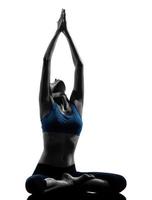 vrouw in yoga pose haar armen strekken in de lucht