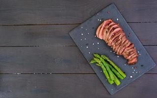 gegrilde biefstuk en asperges op houten achtergrond foto