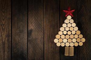 kerstboom gemaakt van wijnkurken op houten ondergrond. mockup ansichtkaart met kerstboom en kopieer ruimte voor tekst. bovenaanzicht.