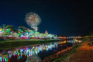 vuurwerk aan de waterkant met lichten in phitsanulok, thailand. foto