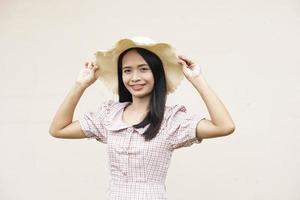 Aziatische vrouw die een hoed draagt die gelukkig glimlacht foto