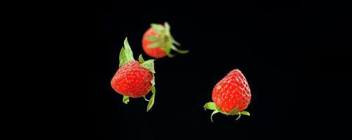 verse aardbeien, aardbeien geïsoleerd op een zwarte achtergrond. foto